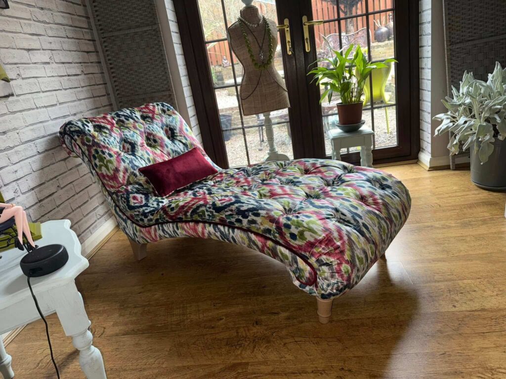 Chaise in the middle of a room with double doors leading outside